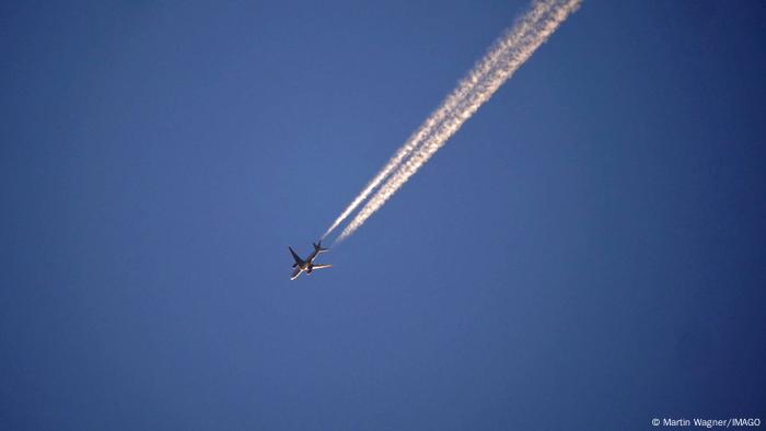 Flugzeug mit Kondensstreifen am Himmel