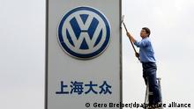 ARCHIV - Ein Arbeiter reinigt das Firmenschild eines Volkswagen Autohauses am 13.10.2005 in der Nähe von Schanghai. Nachdem China 1978 den Weg zu einer «sozialistischen Marktwirtschaft» einschlug, blühte der Handel des Riesenreichs mit anderen Ländern auf.(zu dpa «Die Entwicklung der deutsch-chinesischen Handelsbeziehungen» vom 28.12.2017) Foto: Gero Breloer/dpa +++ dpa-Bildfunk +++