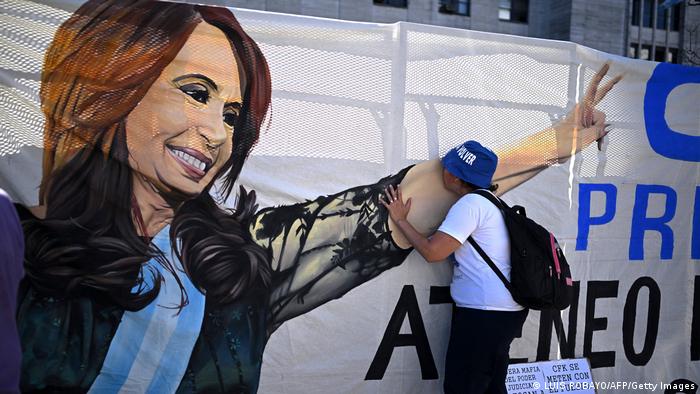 Un partidario de la vicepresidenta argentina Cristina Fernández de Kirchner besa su imagen en una enorme pancarta colgada frente al Palacio de Justicia.