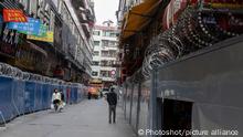 People pass by walls enclosing buildings under the Covid-19 lockdown in Guangzhou in south China's Guangdong province Tuesday, Dec. 06, 2022., Credit:JULIEN TAN / Avalon