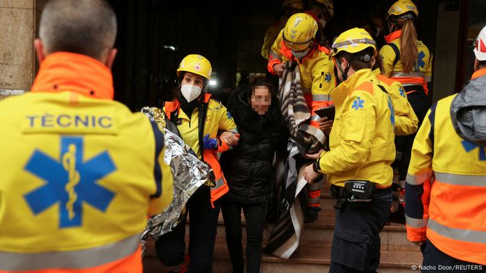 Fuerzas de rescate ayudan a una persona a salir del lugar del accidente de trenes.