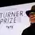 Veronica Ryan, woman with a hat on stage of the Turner Prize 2022, smiling