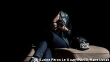 FRANCE - ILLUSTRATIVE - PHOTOJOURNALIST AT HOME A phojournalist woman dressed in a leather jacket holds a camera next to a press helmet, sitting on a sunny couch, from my series containment, variations around a ray of sunshine. VERSAILLES ILE DE FRANCE - IDF FRANCE PUBLICATIONxINxGERxSUIxAUTxONLY Copyright: xKarinexP ronxLexOuayx HL_KPERONLEOUAY_1109196