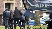 07.12.2022, Baden-Württemberg, Karlsruhe: Eine Person (2.v.r.) wird von Polizisten aus einem Hubschrauber gebracht. Die Bundesanwaltschaft hat am Mittwochmorgen mehrere Menschen aus der sogenannten Reichsbürgerszene im Zuge einer Razzia festnehmen lassen. Zahlreiche Beamte waren in mehreren Bundesländern im Einsatz, sagte eine Sprecherin der Karlsruher Behörde. Beim Bundesgerichtshof in Karlsruhe sollen die Haftprüfungen stattfinden. Foto: Uli Deck/dpa +++ dpa-Bildfunk +++