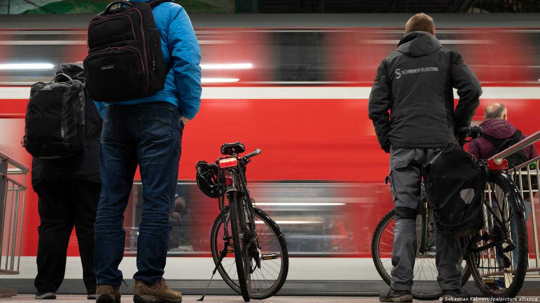 Tren istasyonunda yanlarında bisikletleri ile tren bekleyenler