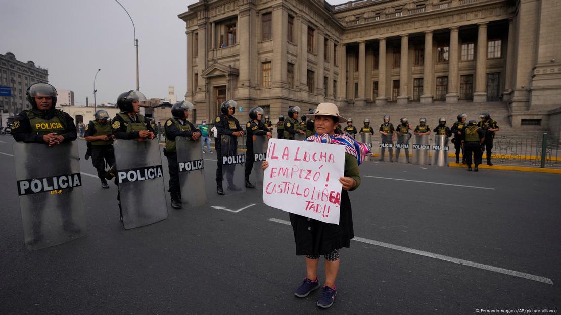 Seguidora de Castillo segura cartaz de apoio ao ex-presidente em frente ao Palácio do Governo, em Lima