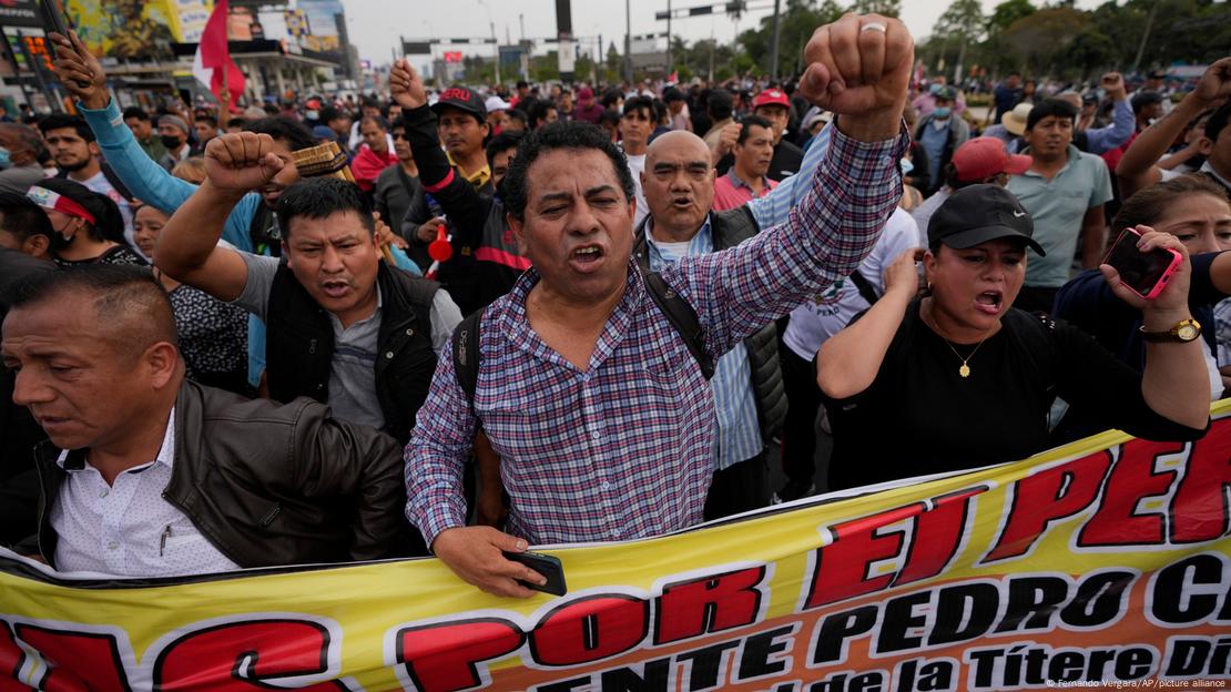 Homens protestando com faixa e punho erguido