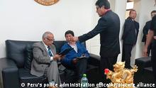 In this photo provided by Peru's police administration office, former President Pedro Castillo, second from left, and former Prime Minister Anibal Torres, far left, sit as prosecutor Marco Huaman stands at center inside a police station, where Castillo and Torres' status was not immediately clear, in Lima, Peru, Wednesday, Dec. 7, 2022. Peru's Congress removed Castillo from office Wednesday and replaced him with the vice president, shortly after the president decreed the dissolution of the legislature ahead of a scheduled vote to oust him. (Peru's police administration office via AP)