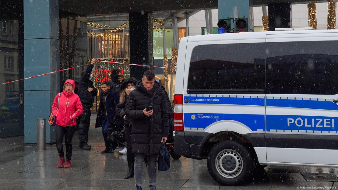 People walk as police officers secure the area at a Christmas market in Dresden