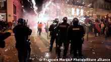 French gendarmes stand by fire works after the World Cup quarterfinal soccer match on the Champs Elysee Avenue, in Paris, Saturday, Dec. 10, 2022. (AP Photo/Francois Mori)
