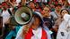 Protesto em Lima no domingo, 11/12; manifestante à frente na imagem empunha megafone, enquanto fundo da foto é coberto por dezenas de pessoas na capital peruana.