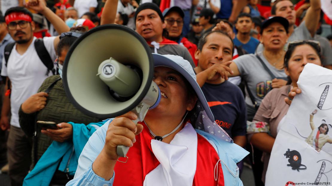 Protesto em Lima no domingo, 11/12; manifestante à frente na imagem empunha megafone, enquanto fundo da foto é coberto por dezenas de pessoas na capital peruana.