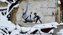 Illustration picture shows a Banksy graffiti showing a small boy throwing a grown up man in judo attire over his shoulder, painted on a piece of wall, during a visit to Borodianka in the Kyiv Oblast (province), on the second day of a visit to Ukraine, on Sunday 27 November 2022. Most of the buildings in Borodianka, a small town on an important access road to Kyiv, have been destroyed by Russian bombings in the first months of the Russian invasion. Prime Minister De Croo and Minister of Foreign Affairs Lahbib arrived in the Ukrainian capital Kyiv on Saturday for an unannounced visit. Nine months ago, Russia invaded the neighboring country. Belgium will provide additional support to Ukraine. De Croo and Lahbib use the visit to announce additional Belgian support of around 37.4 million euros. BELGA PHOTO POOL PHILIP REYNAERS
