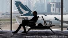 A Man sitting on a chair in front of a Plane Belonging to Cathay Pacific Airways Limited at Hong Kong International Airport on November 27, 2022 in Hong Kong, China. (Photo by Vernon Yuen/NurPhoto)