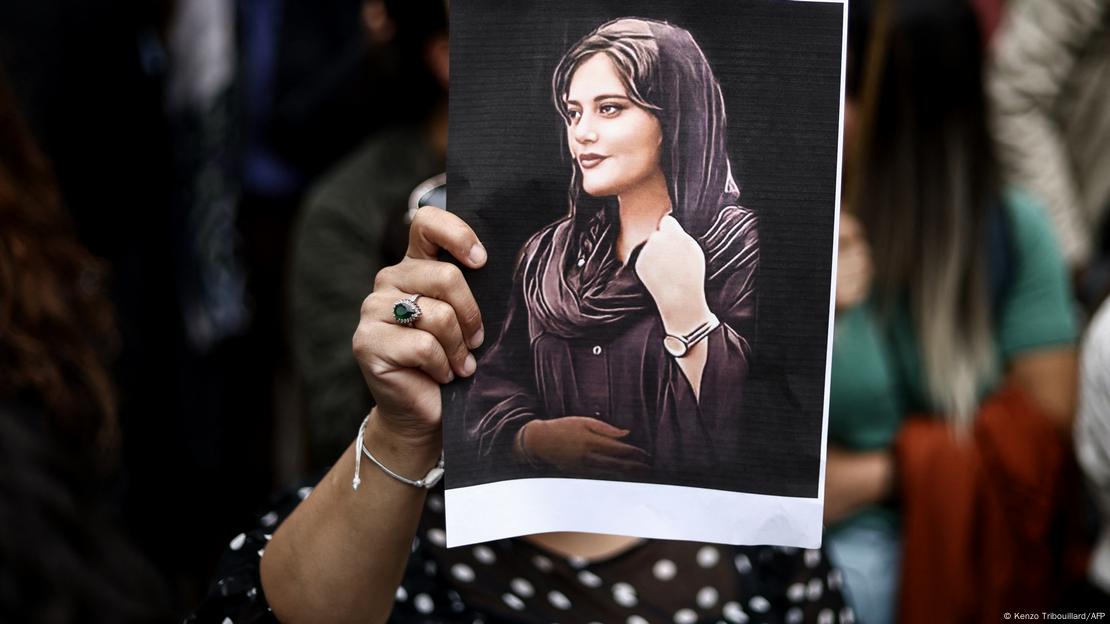 Manifestante segura retrato da jovem iraniana Jina Mahsa Amini, morta aos 22 anos em 16 de setembro de 2022 sob custódia da polícia da moral do Irã.