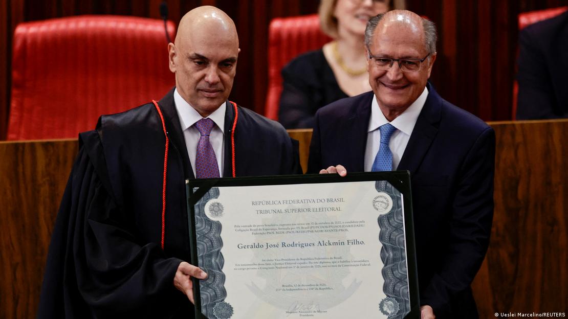 Moraes e Alckmin segurando diploma e olhando para a frente
