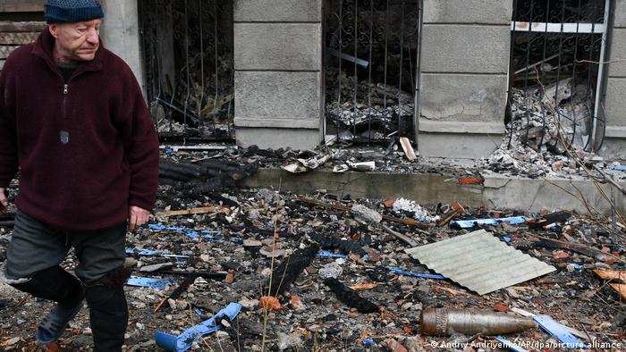 Ukraine, Bachmut: Ein Mann geht an einem Blindgänger vorbei, der zwischen Trümmer liegt (11.12.2022)