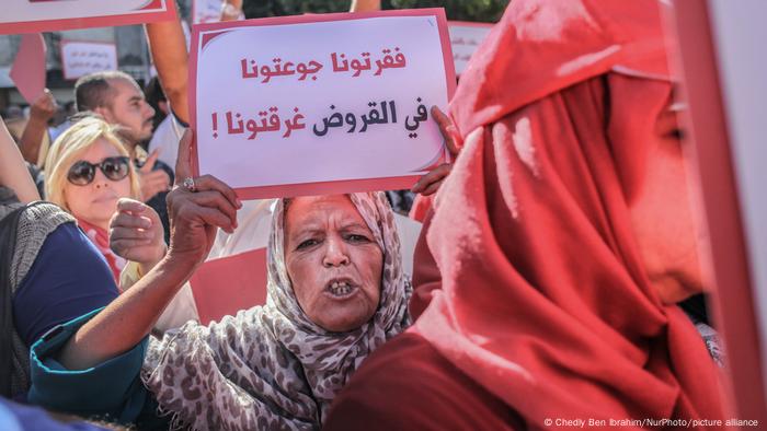 سيدة تونسية تشارك في تظاهرة وترفع لوحة بها شعار احتجاجا على الأوضاع الاجتماعية - تونس أكتوبر 2022