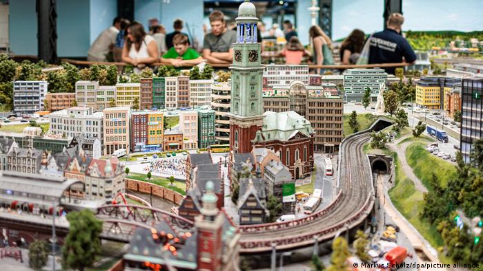 Casitas y ferrocarril de Miniatur Wunderland, Hamburgo, con gente al fondo.