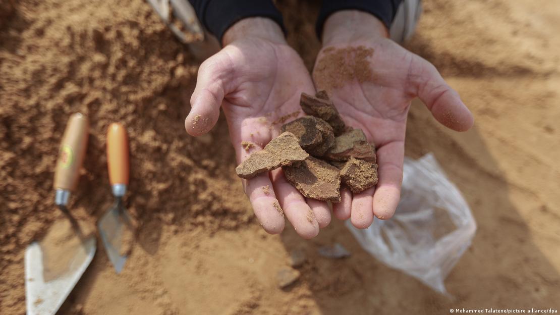 A Palestinian worker holds some excavated items from a Roman-era cemetery 