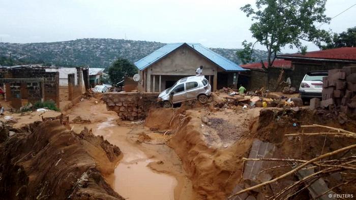 Blick auf eine Häuseransammlung, deren Straßen und anderes Gelände von den Wassermassen unterspült und weggerissen wurden