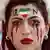 An Iran supporter with her face made up to show tears of blood under a heart in the Iranian colours