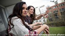 ILLUSTRATION - Zwei junge Frauen beobachten am 08.03.2019 von einem Balkon einer Wohnung in Hamburg das Geschehen vor dem Haus (gestellte Szene). Foto: Christin Klose || Modellfreigabe vorhanden