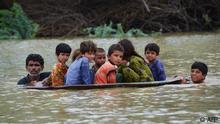 -- AFP PICTURES OF THE YEAR 2022 --
A man (L) along with a youth use a satellite dish to move children across a flooded area after heavy monsoon rainfalls in Jaffarabad district, Balochistan province, on August 26, 2022. - Heavy rain continued to pound parts of Pakistan on August 26 after the government declared an emergency to deal with monsoon flooding it said had affected over four million people. (Photo by Fida HUSSAIN / AFP) / AFP PICTURES OF THE YEAR 2022