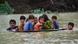 A man along with a youth use a satellite dish to move children across a flooded area after heavy monsoon rainfalls A man along with a youth use a satellite dish to move children across a flooded area after heavy monsoon rainfalls