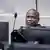 Dominic Ongwen sits behind a computer as he waits for judges to deliver their judgement on the appeals case