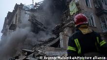 Ukrainian State Emergency Service firefighters clear the rubble at the building which was destroyed by a Russian attack in Kryvyi Rih, Ukraine, Friday, Dec. 16, 2022. Russian forces launched at least 60 missiles across Ukraine on Friday, officials said, reporting explosions in at least four cities, including Kyiv. At least two people were killed by a strike on a residential building in central Ukraine, where a hunt was on for survivors. (AP Photo/Evgeniy Maloletka)