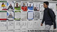 14.12.2022
A youth walks past electoral posters for candidates running in the Tunisian national election scheduled for December 17, glued on a wall along the side of a road in Tunisia's capital Tunis on December 14, 2022. (Photo by FETHI BELAID / AFP) (Photo by FETHI BELAID/AFP via Getty Images)