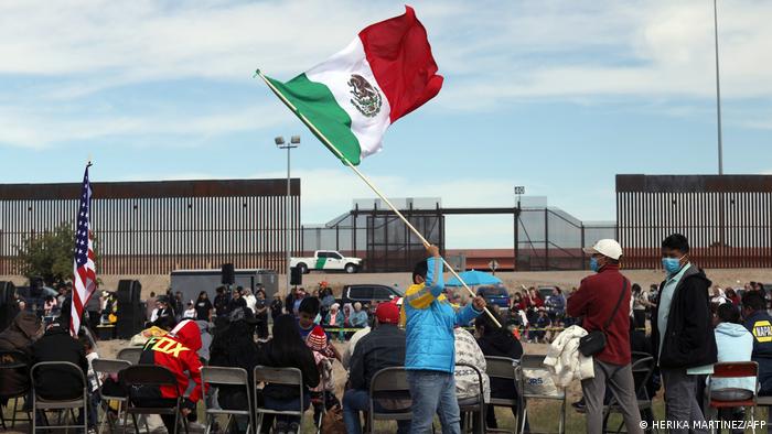 Un hombre levanta la bandera de México en un acto en memoria de los migrantes fallecidos en la frontera con EE.UU. (Archivo: 05.11.2022)