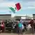 Un hombre levanta la bandera de México en un acto en memoria de los migrantes fallecidos en la frontera con EE.UU. (Archivo: 05.11.2022)