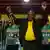 South African President Cyril Ramaphosa holds his hands in the arm in victory