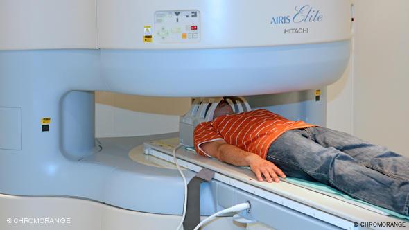 شخص يخضع لفحص بجهاز التصوير بالرنين المغناطيسي (MRI) شخص يخضع لفحص بجهاز التصوير بالرنين المغناطيسي (MRI)