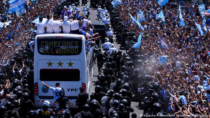 Una multitud de personas recibe a los jugadores de la selección argentina, campeona de la Copa Mundial de Fútbol 2022, a lo largo de su reccorido por las calles de Buenos Aires