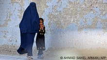 A burqa-clad woman walks with a girl along a street in Kabul on May 7, 2022. - The Taliban on May 7 imposed some of the harshest restrictions on Afghanistan's women since they seized power, ordering them to cover fully in public, ideally with the traditional burqa. (Photo by Ahmad SAHEL ARMAN / AFP) / ìThe erroneous mention[s] appearing in the metadata of this photo by Ahmad SAHEL ARMAN has been modified in AFP systems in the following manner: [Quality correction]. Please immediately remove the erroneous mention[s] from all your online services and delete it (them) from your servers. If you have been authorized by AFP to distribute it (them) to third parties, please ensure that the same actions are carried out by them. Failure to promptly comply with these instructions will entail liability on your part for any continued or post notification usage. Therefore we thank you very much for all your attention and prompt action. We are sorry for the inconvenience this notification may cause and remain at your disposal for any further information you may require.î