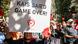 A female demonstrator at a rally holding a sign that reads, "Kais Saied Game Over" A female demonstrator at a rally holding a sign that reads, "Kais Saied Game Over"