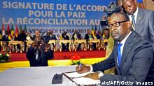 Malian Foreign Affairs Minister Abdoulaye Diop signs a peace accord between Mali's government and several armed groups during a ceremony attended by African heads of state on May 15, 2015 in Bamako. Mali's government and several armed groups signed a peace accord May 15 in a ceremony attended by numerous heads-of-state but missing the crucial backing of the main Tuareg-led rebel groups. The Coordination of Azawad Movements (CMA) had provisionally initialled the document a day earlier but is demanding concessions and its three principal factions did not attend the rubber-stamping ceremony in the Malian capital Bamako. AFP PHOTO / HABIBOU KOUYATE (Photo credit should read HABIBOU KOUYATE/AFP via Getty Images)