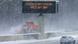 A signboard blares a winter storm warning along a road in the US A signboard blares a winter storm warning along a road in the US