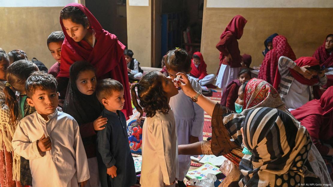 Una trabajadora de salud administra gotas de la vacuna contra la polio a niños en una escuela de Pakistán