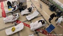 Covid-19 coronavirus patients lie on hospital beds in the lobby of the Chongqing No. 5 People's Hospital in China's southwestern city of Chongqing on December 23, 2022. (Photo by Noel CELIS / AFP)