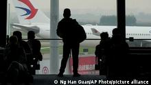A passenger looks on as a China Eastern flight taxi on the runway of Baiyun Airport on Friday, March 25, 2022, in southern China's Guangzhou province. China Eastern, one of China's four major airlines, said Thursday the Shanghai-based carrier and its subsidiaries have grounded a total of 223 Boeing 737-800 aircraft while they investigate possible safety hazards after the crash of its flight MU5735 on Monday. (AP Photo/Ng Han Guan)