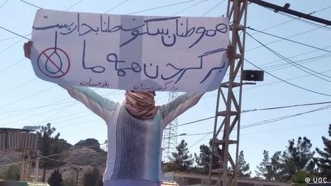 یک معترض بلوچ با نوشتەای در دست، با عنوان "هموطنان، سکوت طناب داریست بر گردن همە ما".