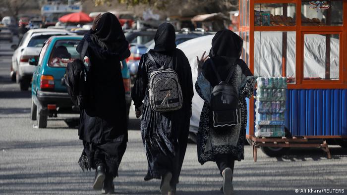 Tres estudiantes caminan cerca de la Universidad de Kabul.