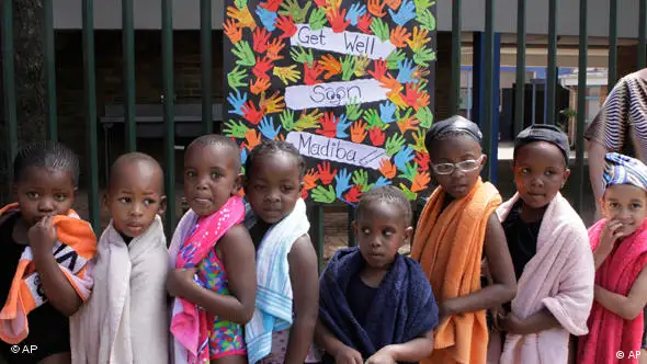 Schulkinder aus Südafrika vor einem Schild mit Genesungswünschen für Nelson Mandela (Foto: AP)