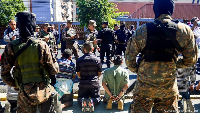 Miembros del ejército salvadoreño vigilan a presuntos pandilleros detenidos en San Salvador. (Archivo: 24.12.2022)