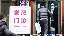 A photo shows an outpatient treatment of fever at a hospital in central Beijing, China on December 25, 2022. A staff member clad in protective suits is seen at the entrance. Hospitals in urban areas have been to be tight by the effects of the ease of the new coronavirus COVID-19 measures.( The Yomiuri Shimbun via AP Images )