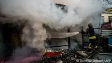 A rescuer extinguishes a fire in a burning shop after Russian shelling to Ukrainian city of Kherson on December 24, 2022, where five were killed and 20 injured. - Ukrainian President Volodymyr Zelensky on December 24, 2022 blasted Russian terror after shelling left at least five dead and 20 injured in Kherson city, which Kyiv's forces recaptured in November. (Photo by Dimitar DILKOFF / AFP)